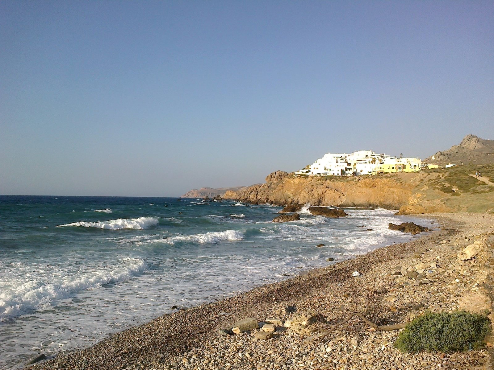 Strand op Naxos in de Cycladen met witgekalkte huizen op de achtergrond